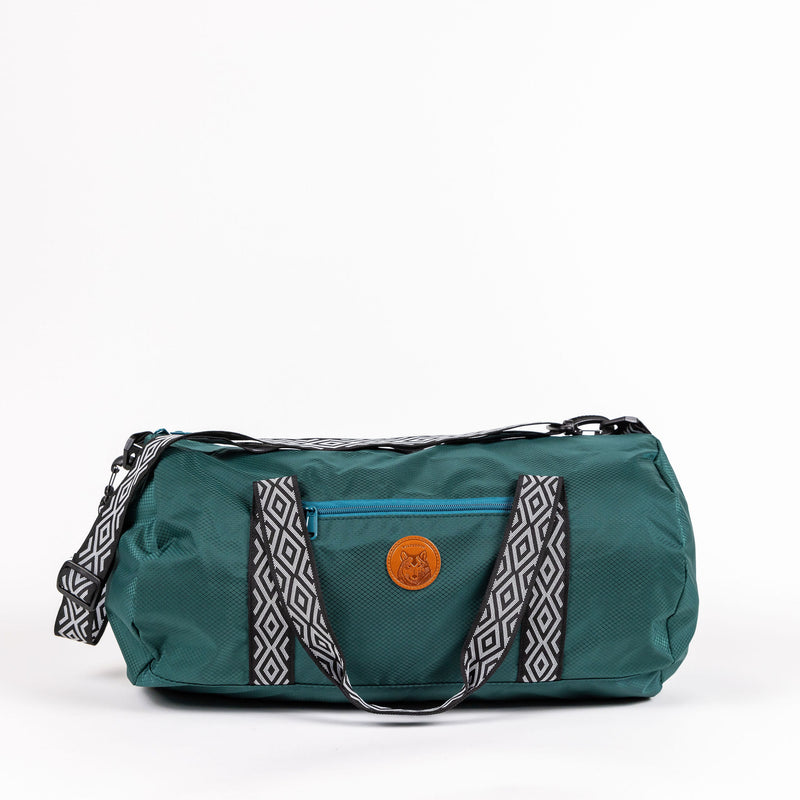 Green Dog Duffel with patterned straps, blue pocket, leather patch, and detachable shoulder strap.