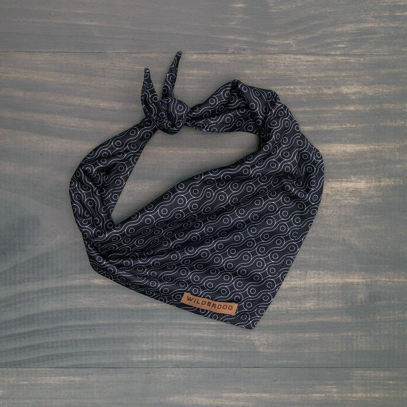 Off The Chain Bandana, black with circular pattern and "Wilderdog" tag, laid flat.