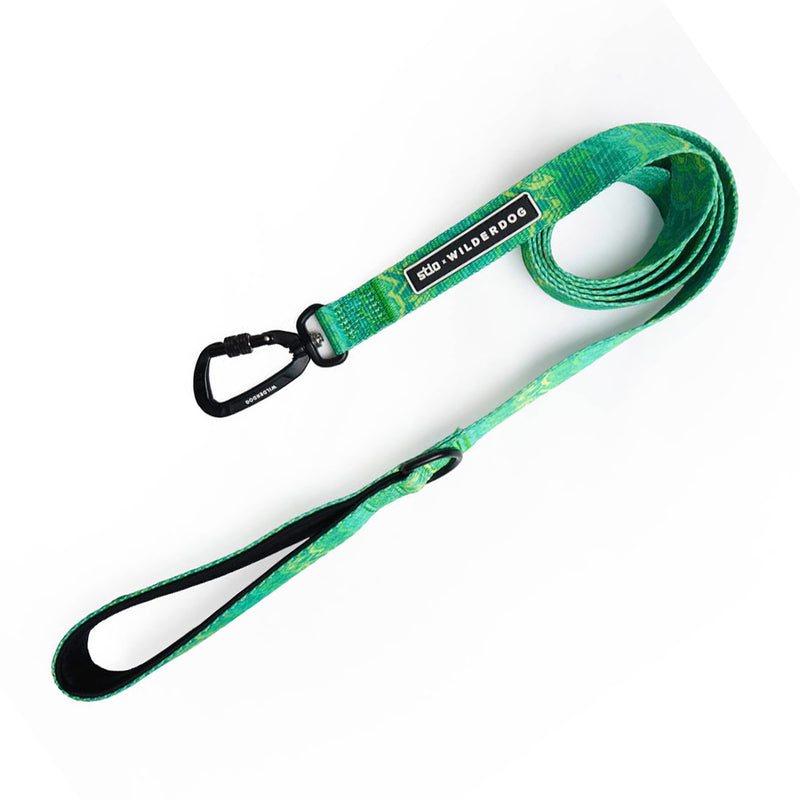The Smartcart21 x Stio Ultralight Leash is a durable dog leash featuring Teton-inspired designs in green and blue. It includes a black clasp and handle, with a small black tag that reads "WILD ONE" stitched near the clasp. The ultralight leash is coiled neatly in the image.