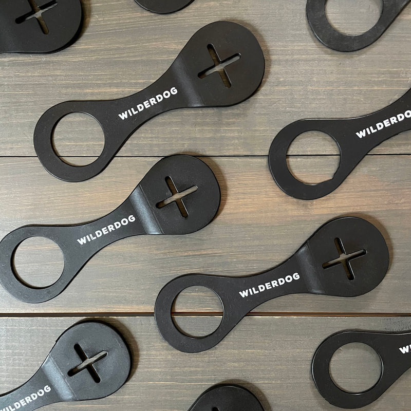Black Smartcart21 bottle openers, each with a circular hole, cross-shaped cutout, and printed logo.