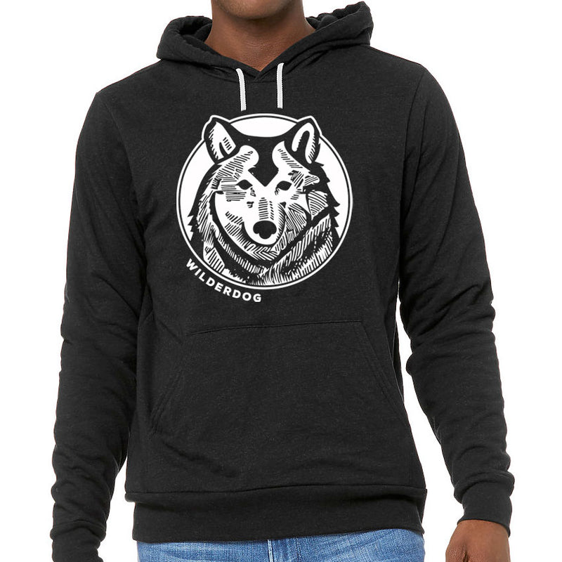 A person wearing the Smartcart21 Hoodie, a black unisex sweatshirt featuring a white graphic of a husky dog face inside a circle on the chest, with the word "WILDERDOG" written below the graphic. This ultra-soft hoodie includes a kangaroo pocket and pairs perfectly with blue jeans.