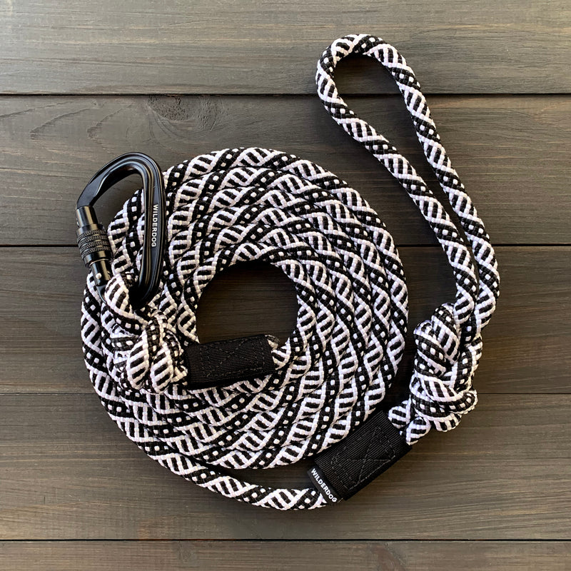 Black and White Leash with a locking carabiner, coiled neatly and featuring a patterned weave