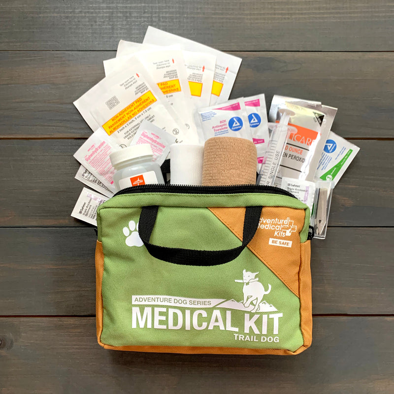 Green and brown Adventure Dog Series Medical Kit open, showing bandages, gauze, wipes, and bottles